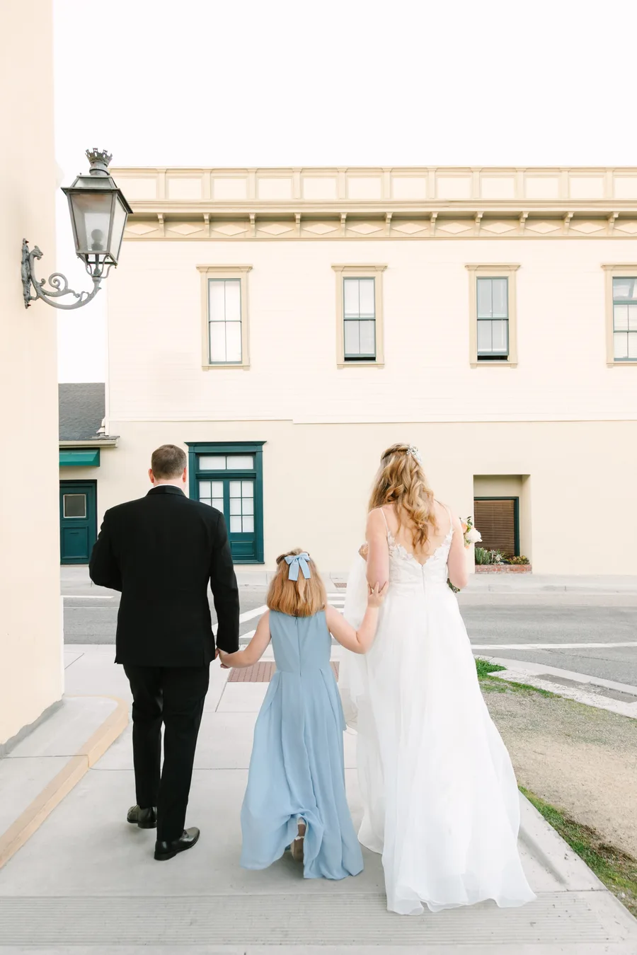 Luke, Mia, and Jessica walking together through historic Monterey on their wedding day